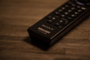 A remote control sitting on top of a wooden table.