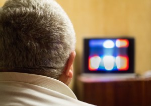 A man sitting in front of a television.